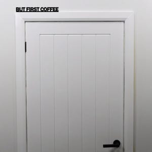 Black acrylic BUT FIRST COFFEE sign installed above a kitchen doorway.