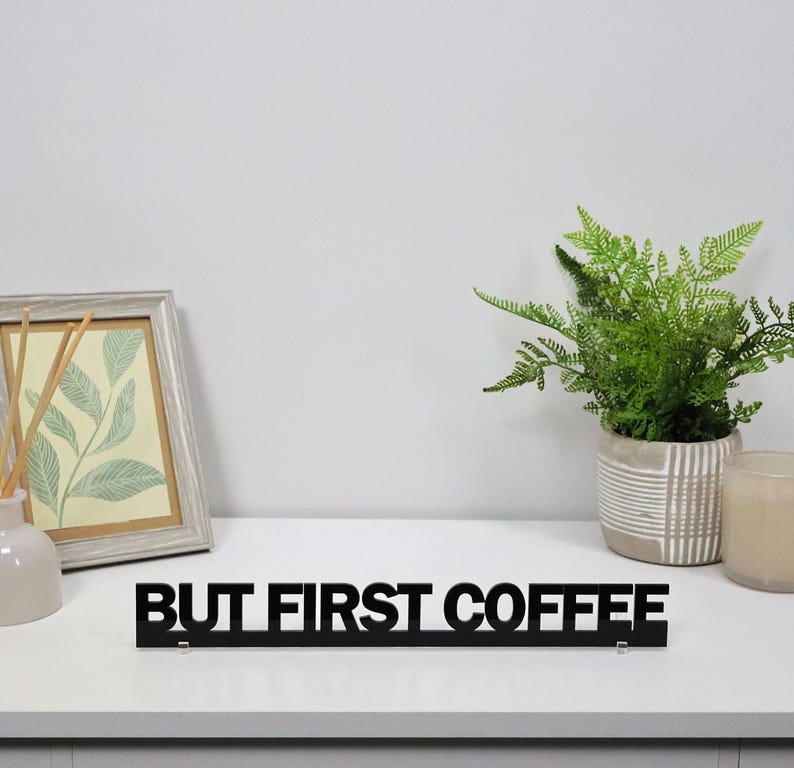 Black acrylic BUT FIRST COFFEE sign displayed alongside coffee station decor, adding personality and style to kitchens, breakfast areas and home coffee bars.