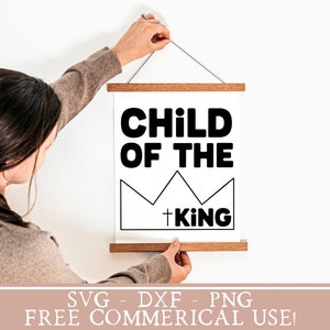 May include: A white printable sign with black text that reads "Child of the King" with a crown graphic. The sign is hanging on a white wall.