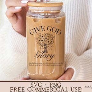 May include: A glass jar with a brown lid and a straw, filled with a brown liquid. The jar has a black and white design that says "Give God Glory" and a Bible verse.