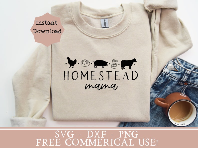 Op de afbeelding: Een beige sweatshirt met de tekst "HOMESTEAD mama" en een rij zwarte silhouetten van een kip, een brood, een varken, een pot melk en een koe.