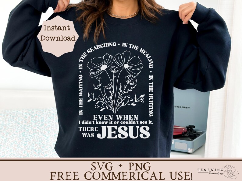 May include: A black sweatshirt with a white graphic design featuring a floral motif and the text "In the waiting, in the searching, in the healing, in the hurting. Even when I didn't know it or couldn't see it, there was Jesus."