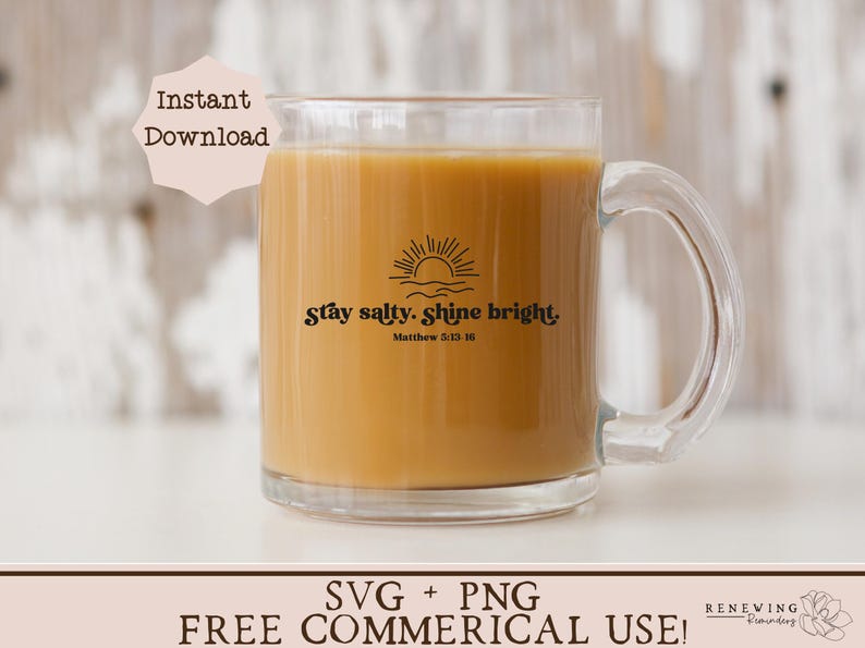 May include: A clear glass mug filled with a light brown liquid, featuring the text "Stay salty. Shine bright." with a sun and wave design. The mug has a handle and is suitable for hot beverages. The text also includes the Bible verse Matthew 5:13-16.
