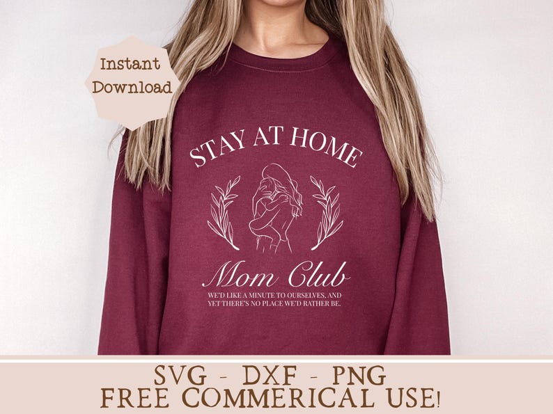 May include: A maroon sweatshirt with the text "Stay at Home Mom Club" in white. The design features a line drawing of a mother and child with floral accents. The text below the design reads "We'd like a minute to ourselves, and yet there's no place we'd rather be."