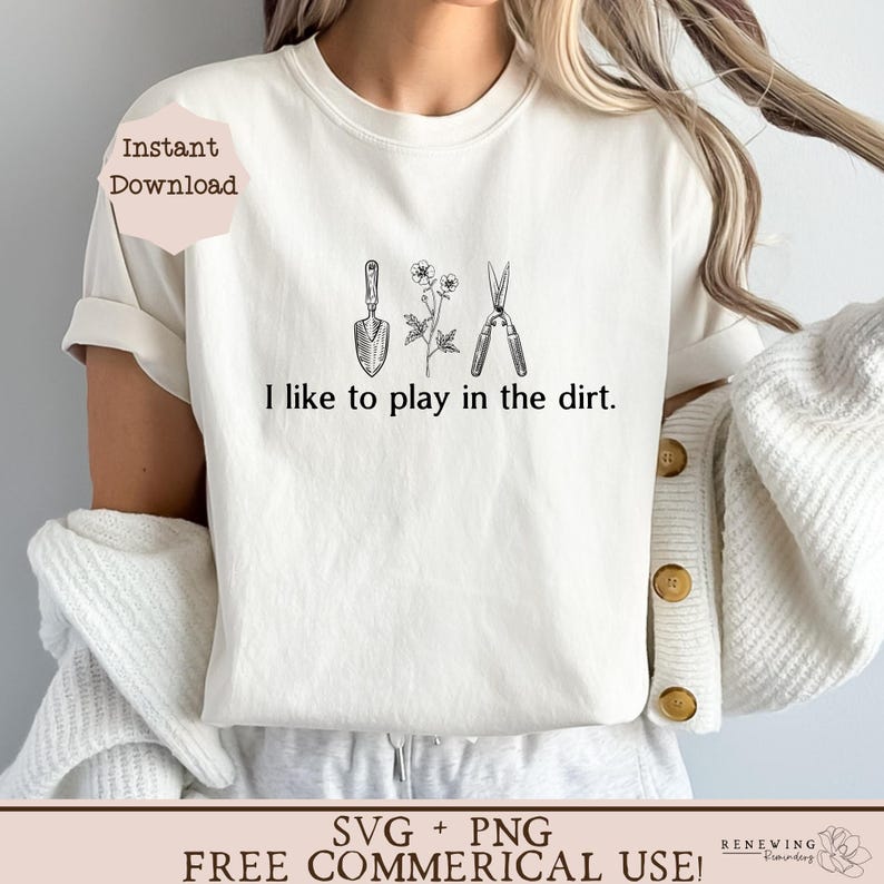 May include: White t-shirt with a gardening theme. The shirt has a graphic of a trowel, a flower, and a pair of pruning shears. The text "I like to play in the dirt." is printed below the graphic.