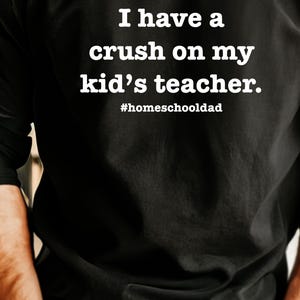 May include: A black t-shirt with the text "I have a crush on my kid's teacher." and the hashtag "#homeschooldad" printed in white.