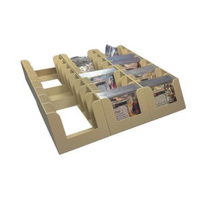 May include: A beige, multi-compartment card organiser made of flat-packed panels. The structure features several rows and slots designed to hold stacks of rectangular game cards, with some sections currently filled with card decks in clear plastic sleeves.
