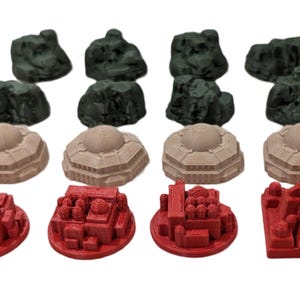 以下が含まれることがあります： 8つの緑色の岩の地形ベース、6つのベージュのドーム型の建物、1つの塔のある赤い建物を含む、3Dプリントされたミニチュアの建物のセット15個。