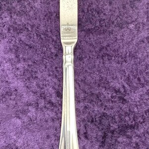 May include: A silver dinner knife with a textured blade and a simple, elegant handle.