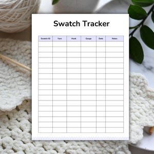 May include: A white Swatch Tracker sheet with a grid for recording yarn details. The sheet is surrounded by crochet items, yarn, and crochet hooks. The text "Swatch Tracker" is at the top of the sheet.