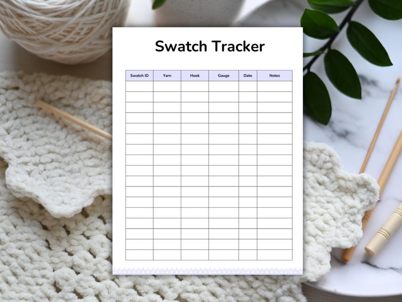 May include: A white Swatch Tracker sheet with a grid for recording yarn details. The sheet is surrounded by crochet items, yarn, and crochet hooks. The text "Swatch Tracker" is at the top of the sheet.