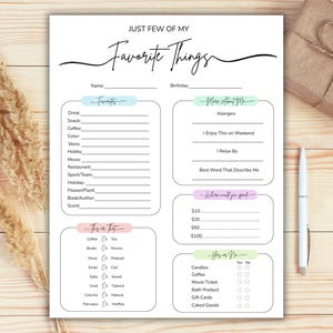 Pode incluir: Um papel branco intitulado "Just Few of My Favorite Things" com seções para preencher com preferências pessoais. Inclui seções para favoritos, sobre mim e perguntas sim ou não. Uma caneta e um presente embrulhado estão ao lado.