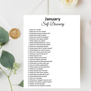 May include: A white sheet of paper with the title "January Self-Discovery" and a list of 31 questions for self-reflection. The paper is surrounded by decorative elements, including a gold wax seal and greenery.