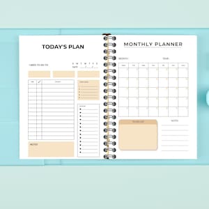May include: An open planner with a blue cover. The left page is labeled "Today's Plan" and has sections for "I need to go to", "Time", "Activity", "Today's Tasks", and "Notes". The right page is labeled "Monthly Planner" and has sections for "Month", "Year", "To Do List", and "Notes".