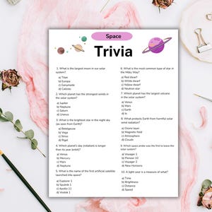 Puede incluir: Una hoja blanca con el t&iacute;tulo "Space Trivia" y preguntas sobre el espacio. El dise&ntilde;o incluye ilustraciones de planetas y estrellas. El fondo es rosa suave con elementos decorativos.