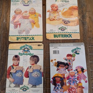 May include: Four Cabbage Patch Kids Butterick sewing pattern envelopes labeled 3269, 6661, 6662, and 4556. The envelopes feature illustrations of dolls wearing various outfits, including dresses, shirts, and a doll carrier, with brand logos and text.
