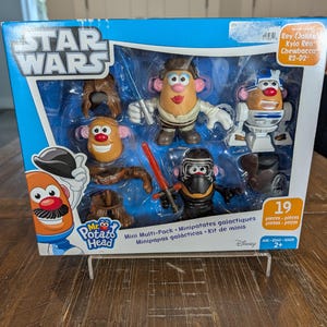 May include: A Star Wars Mr. Potato Head mini multi-pack featuring characters Rey, Kylo Ren, Chewbacca, and R2-D2. The box is blue and white with the Star Wars logo and the Mr. Potato Head logo. Includes 19 pieces.