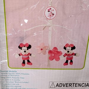 May include: A Disney baby musical mobile featuring Minnie Mouse figures and pink flower accents. The mobile plays "Brahms Lullaby" and is designed for cribs. The packaging includes the text "Sweeter dreams for your sleeping baby."