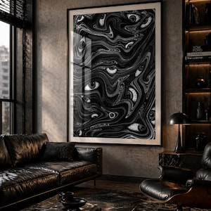 May include: A large framed art print featuring a black and white abstract design of multiple eyes. The artwork is displayed in a modern living room with a leather sofa, armchair, and marble coffee table. The room has a dark, moody aesthetic.