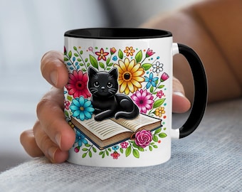 Koffiemok met zwarte kat, kleurrijke bloemen en een open boek, een gezellig cadeau voor boekenliefhebbers, kattenmoeders en lezers.