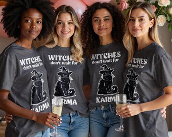 May include: Four women wearing dark gray t-shirts with the text "Witches don't wait for Karma" and a black cat illustration. The women are smiling and holding champagne flutes, with pink balloons and flowers in the background.