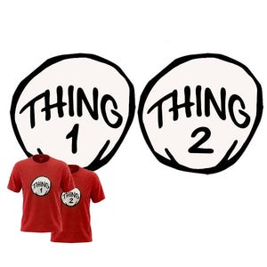 May include: Two red short-sleeved t-shirts featuring a circular white graphic on the chest. One shirt displays the text "THING 1" in black, and the other displays "THING 2" in black, both enclosed within a thick, hand-drawn black circular outline.