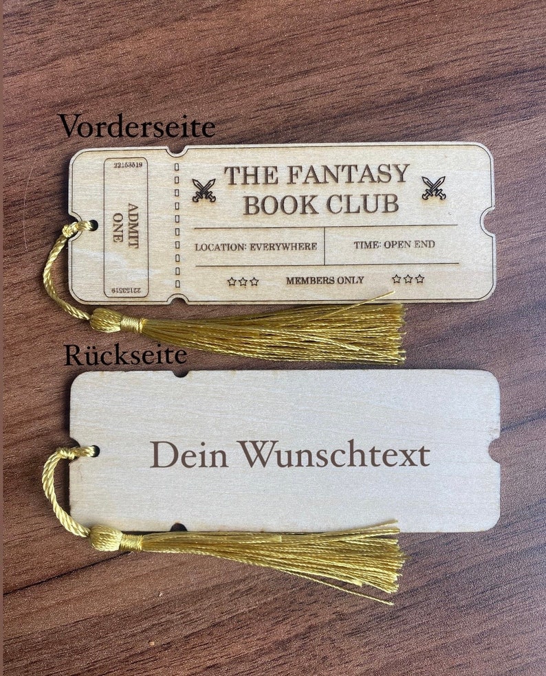 May include: A wooden bookmark shaped like a ticket with the text "The Fantasy Book Club" and "Members Only". The back of the bookmark is blank with the text "Dein Wunschtext".