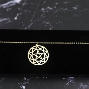 May include: A gold chain necklace with a pendant featuring a geometric star design.