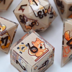 Puede incluir: Juego de dados poliédricos con fondo beige e ilustraciones de Shiba Inu de dibujos animados. Los dados presentan números negros y gráficos de Shiba Inu en cada cara. Para juegos de mesa.