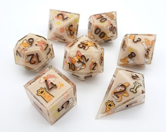 May include: A set of seven polyhedral dice with a beige background and clear resin. Each die features a corgi dog design with orange, white, and brown accents. The numbers are in a dark brown color.