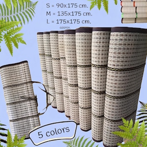 Puede incluir: Cinco esteras de fibra natural enrolladas en varios colores con ribete marrón. Las esteras están disponibles en tres tamaños: pequeña (90x175 cm), mediana (135x175 cm) y grande (175x175 cm).