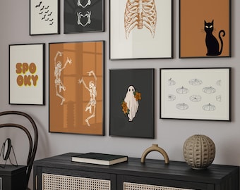 May include: A gallery wall arrangement featuring eight framed prints with Halloween-themed illustrations including bats, skeleton hands forming hearts, a rib cage, a black cat, the word SPOOKY, dancing skeletons, a ghost with flowers, and pumpkins.