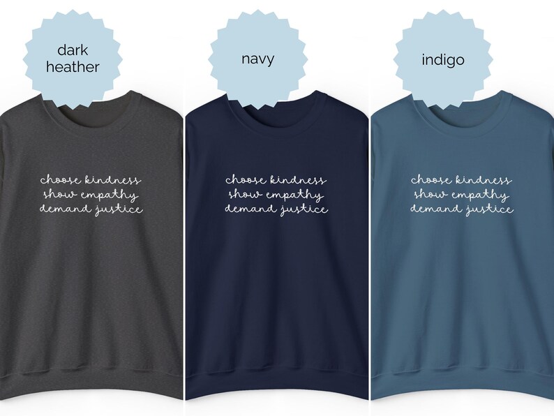 May include: Three crewneck sweatshirts in dark heather, navy, and indigo colors. Each sweatshirt features the white text "choose kindness, show empathy, demand justice" printed in a cursive script font across the center of the chest area.