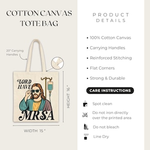 May include: A cotton canvas tote bag with a humorous graphic of a figure wearing sunglasses and the text "LORD HAVE MRSA." The bag has 20-inch carrying handles, is 16 inches high, and 15 inches wide.