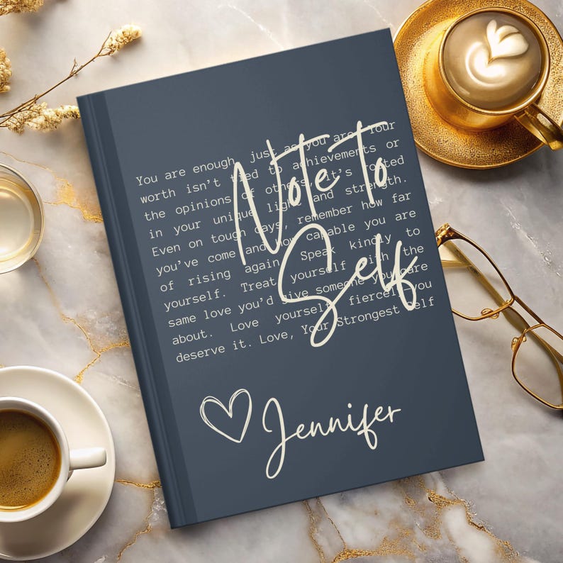 May include: A dark blue journal with the text "Note to Self" in white lettering. The journal has a white heart and the name "Jennifer" written in cursive.