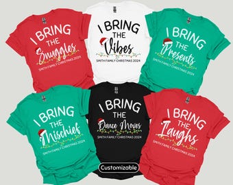 Puede incluir: Seis camisetas con temática navideña con diferentes lemas. Las camisetas son rojas, verdes, negras y blancas. Los lemas en las camisetas son "Yo traigo las caricias", "Yo traigo las vibraciones", "Yo traigo los regalos", "Yo traigo la travesura", "Yo traigo los movimientos de baile", y "Yo traigo las risas".