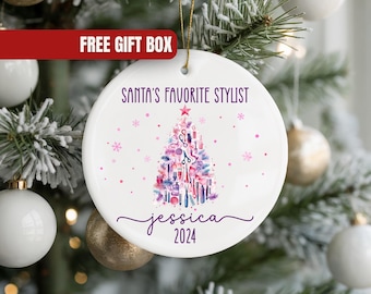 May include: White ceramic Christmas ornament with the text "Santa's Favorite Stylist" in purple. A Christmas tree design is made of beauty tools. The name "Jessica" and the year "2024" are also included.