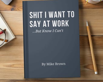 May include: A dark gray hardcover book with white text that reads SHIT I WANT TO SAY AT WORK ...But Know I Can't By Mike Brown. The book is positioned on a wooden surface next to a wooden pencil, a pair of glasses, and a small potted plant.