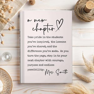 Puede incluir: Un libro blanco con las palabras "a new chapter" y un s&iacute;mbolo de coraz&oacute;n. El texto de abajo dice: "Take pride in the students you've inspired..." y est&aacute; firmado "Mrs. Smith". El libro est&aacute; sobre una superficie de madera clara.