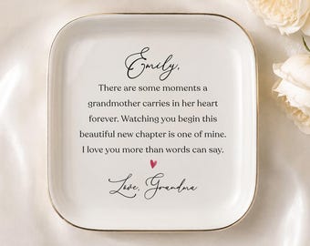 May include: A square white ceramic trinket dish with a gold-toned rim. The center features black printed text: Emily, There are some moments a grandmother carries in her heart forever. Watching you begin this beautiful new chapter is one of mine. I love you more than words can say. Love, Grandma, with a small red heart.