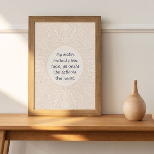 May include: A framed print with a white floral pattern and a quote that reads "As water reflects the face, so one's life reflects the heart."
