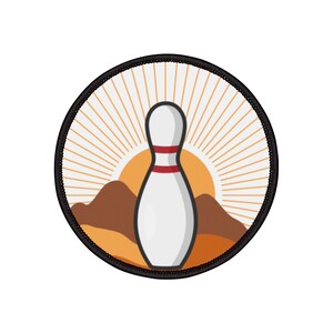 Puede incluir: Un parche redondo con un pin de bolos blanco en el centro, rodeado de un paisaje desértico marrón con un sol amarillo que sale detrás del pin. El parche tiene un borde negro y un diseño de rayos de sol.