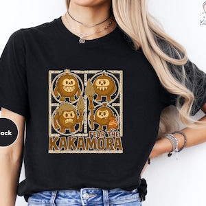 a woman wearing a black shirt with a picture of two pumpkins on it