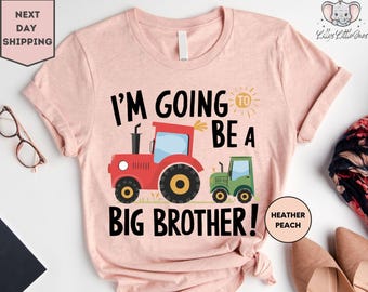 May include: A pink t-shirt with the text "I'm going to be a big brother!" in black. The shirt features a red tractor and a green tractor with a sun graphic. The text "Heather Peach" is in the bottom right corner.