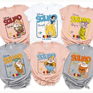 six Disney-themed t-shirts, each featuring a different character from the Snow White and the Seven Dwarfs franchise. The t-shirts are arranged in a grid, with three on the top row and three on the bottom row.