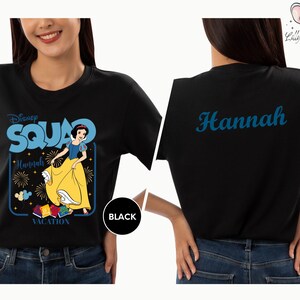 A woman wearing a black t-shirt with a Disney Square design featuring Snow White and the Seven Dwarfs.