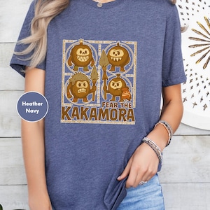 a woman wearing a blue t - shirt with a picture of two monkeys on it