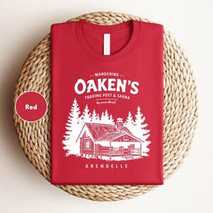 a red t - shirt with a picture of a cabin on it