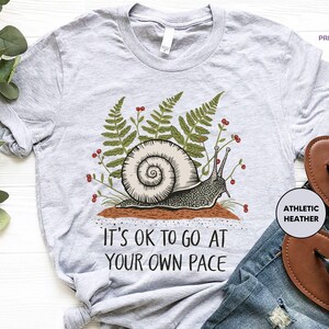 a t - shirt that says it's ok to go at your own pace