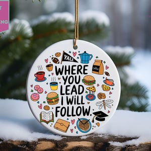 May include: White ceramic ornament with a colorful illustration of food, drinks, and school supplies. The text reads "Where you lead I will follow."